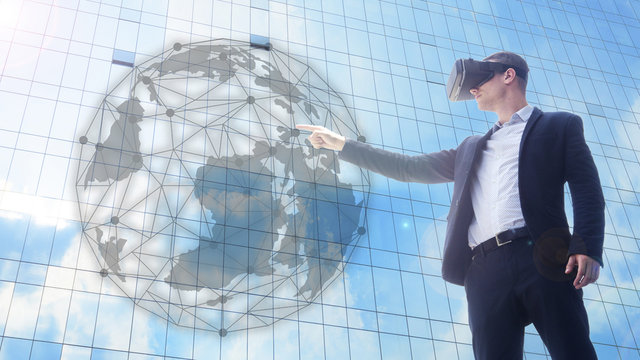 business man using VR headset and interacting with object world display.man getting experience using Visual reality concept with modern exterior building.