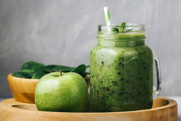 Healthy breakfast, green smoothie in a glass jar and some ingredients - spinach and apple. Superfood, detox food
