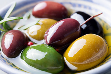 Olives assortment in bowl with oil. Close up.