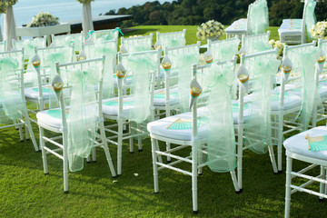 Beautiful wedding set up. Wedding ceremony on green lawn in the terrace. Part of the festive decor, floral arrangement.