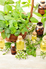 fresh herbs and massage oil on the wooden table