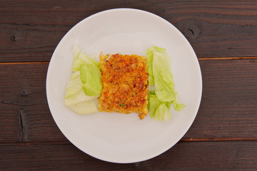 Baked rice with vegetables and salad on a table