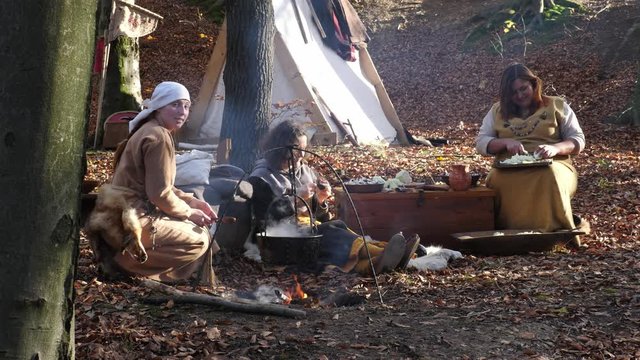 Portrait of Viking women prepare and knit in a forest camp