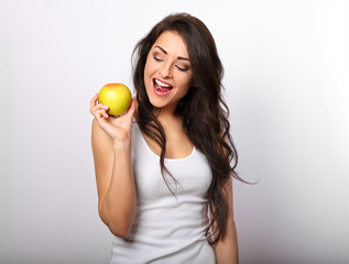 Beautiful excited makeup casual long hair brunette woman holding the red tasty apple and looking happy on empty space white background. Closeup portrait