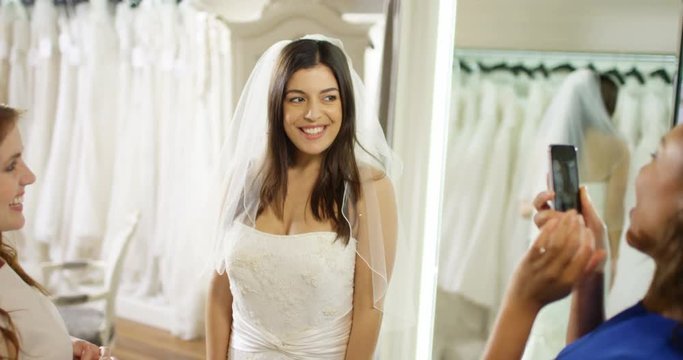 4k, Young woman taking pictures with friends at a bridal store.