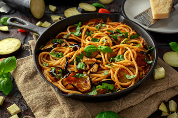 Vegetarian Italian Pasta Spaghetti alla Norma with eggplant, tomatoes, basil and parmesan cheese in...