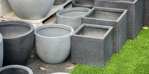 Gray round and square stone flower pots for sale at garden store