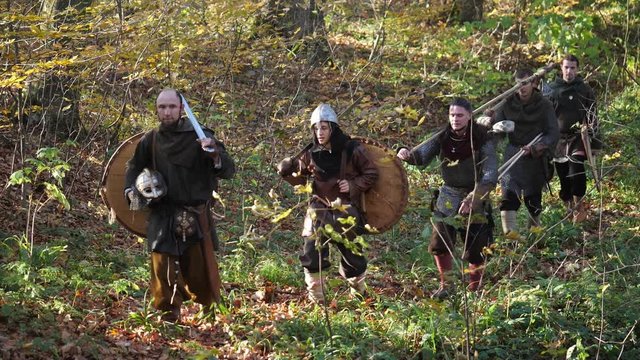 Viking warriors going through the forest after the battle to home