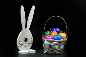 Easter Eggs in Basket with rabbit isolated on black background