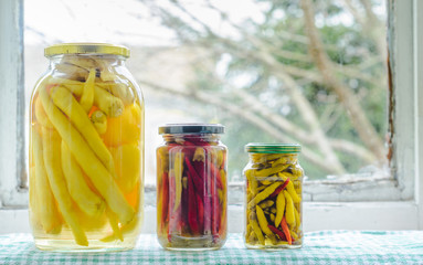 Homemade tasty pickled peppers in a glass jar
