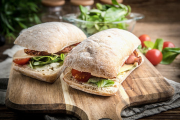 Ciabatta sandwich with arugula salad, bacon and yellow cheese. © Arkadiusz Fajer