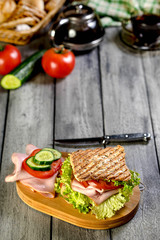 Sandwich with ham, cucumber, tomato and lettuce.