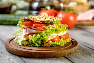 Sandwich with ham, cucumber, tomato and lettuce.