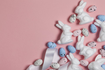 Pastel pink easter holiday background with eggs and easter bunnies