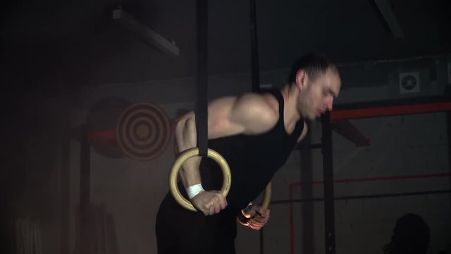 the athlete trains on the rings in the gym