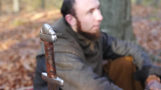 A sword on a background of madieval Viking in th eforest