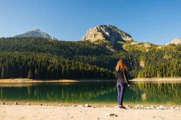Fototapeta na wymiar Young woman at the Black lake in Durmitor national park, Montenegro