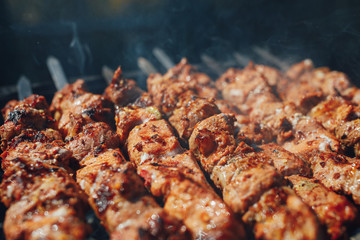 grilled barbecue meat on skewers with smoke