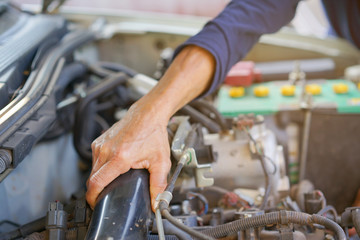 close up on technician man hand checking malfunctional car for repair concept