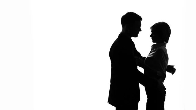 Black-and-white silhouette of chief passionately kissing his female assistant