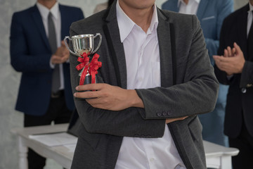 Employee showing the trophy award for success in business.