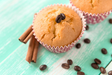 cupcakes with cinnamon sticks and coffee beans on a green wooden background
