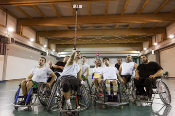 Fototapeta premium group of smiling disabled basketball players take a selfie