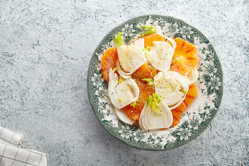 Fresh salad with red orange and fennel on textured background
