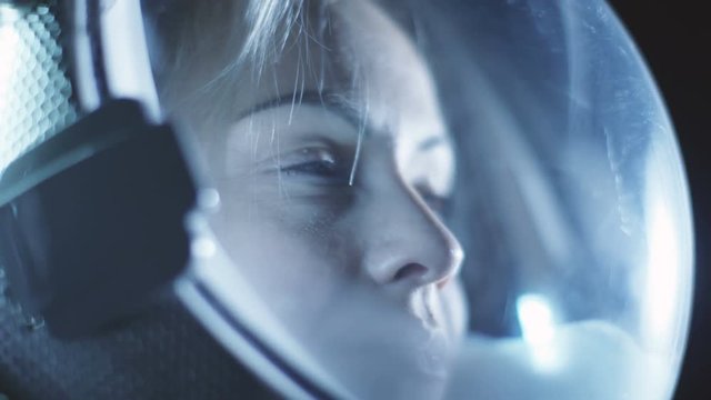 Portrait Shot of the Courageous Female Astronaut  Wearing Helmet in Space, Looking around in Wonder. Space Travel. Shot on RED EPIC-W 8K Helium Cinema Camera.