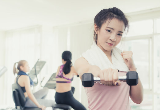 Asian Woman Is Punching The Dumbbell Forward In Fitness