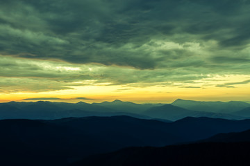 Obraz premium Picturesque summer landscape with colorful sunrise on Carpathian mountains. Mountain ranges in morning light. Travel background concept