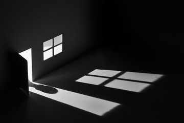 Toy house with light falling through door and window to make a shadow