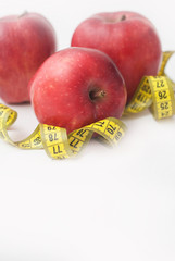 Red Apple with Measure Tape for Loose Weigh, diet and fitness with copy space . Isoalted on White Background. Vertical image.