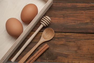 Rustic Bakery and Cooking Concept. Raw Eggs with Wooden Baking Tools. Bake or food Background. Dark rustic Wooden Background with copy space. Flat Lay.