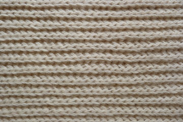 knitted scarf close-up beige knitted fabric yarn wool acrylic cotton natural thread close-knit vintage background for decoration hand-made background made by hand