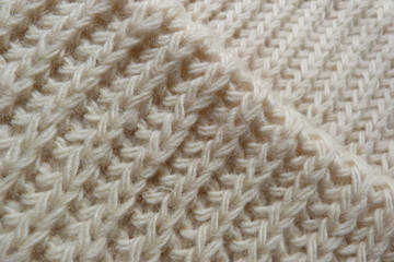 knitted scarf close-up beige knitted fabric yarn wool acrylic cotton natural thread close-knit vintage background for decoration hand-made background made by hand