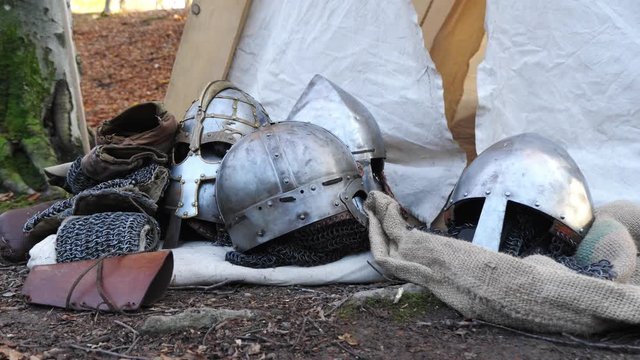 Close-up of the helmets and mail of the Vikings lie near the tent.