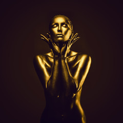 Fototapeta na wymiar Golden lady on dark background