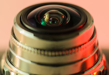 Fototapeta na wymiar Camera lens close - up backlit yellow-red. Horizontal photo.