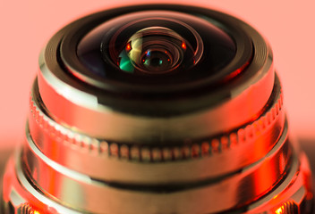 Fototapeta na wymiar Close-up camera lens with red illumination. Horizontal photo.