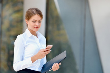 Portrait of cheerful young woman talking on smartphone outdoors