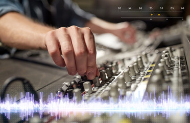 hands on mixing console in music recording studio