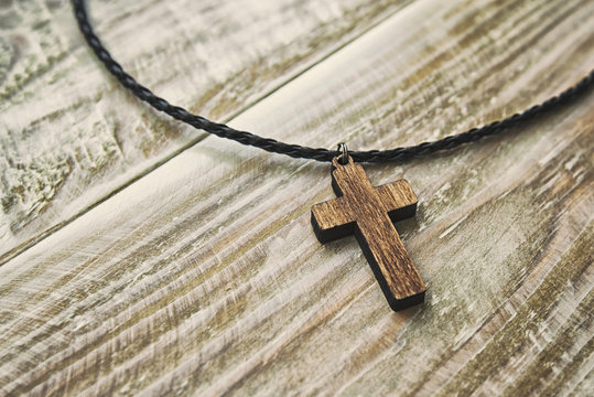 The cross-shaped pendant on the wooden desk
