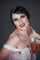 Elegance, Brunette girl with short hair, French mane in the style of the 20s. She wears white fur...