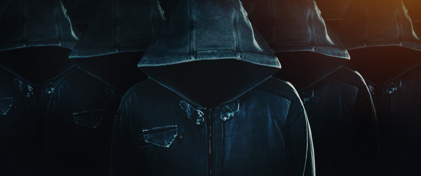 Group of hooded computer hackers with obscured faces