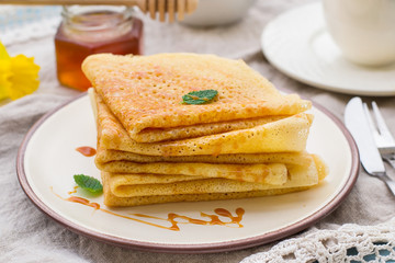 Stack of thin pancakes crepes with caramel topping