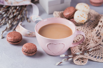 Pink coffee mug with sweet pastel french macaroons, gift box and pussy willow