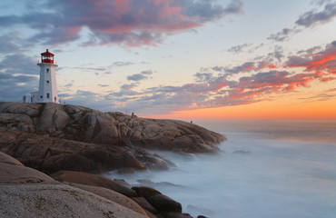 Beautiful Peggy Cove Light House with Sunset, Nova Scotia, Canada. Photo shows tourists watching...