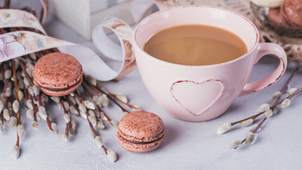 Pink coffee mug with sweet pastel french macaroons, gift box and pussy willow