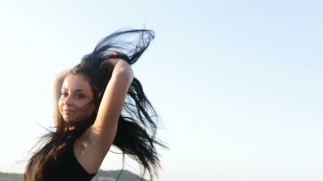 portrait beautiful young brunette woman jumping trampoline smiling female levitation air blue sky background bodysuit fashion show stylish girl model slim figure strong body sun rise sunlight sunny